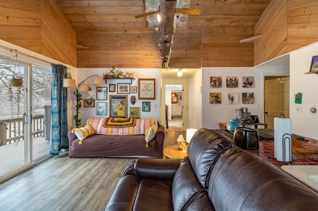 living room with ceiling fan, wood-type flooring, a towering ceiling, and wooden ceiling