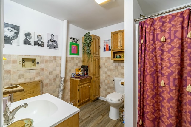 bathroom featuring hardwood / wood-style floors, vanity, tile walls, and toilet