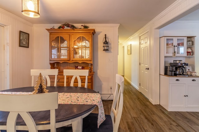 dining area with dark hardwood / wood-style floors, ornamental molding, and a baseboard heating unit