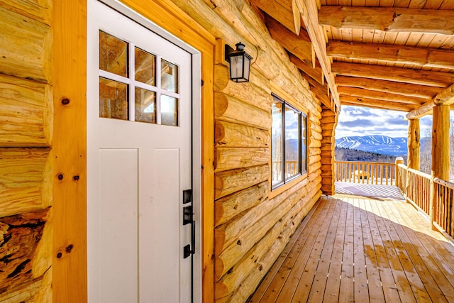 wooden deck with a mountain view and covered porch