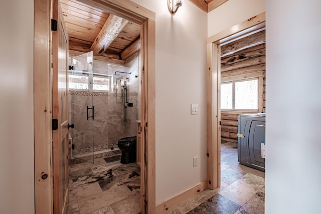 bathroom with washer / dryer, toilet, an enclosed shower, and wood ceiling