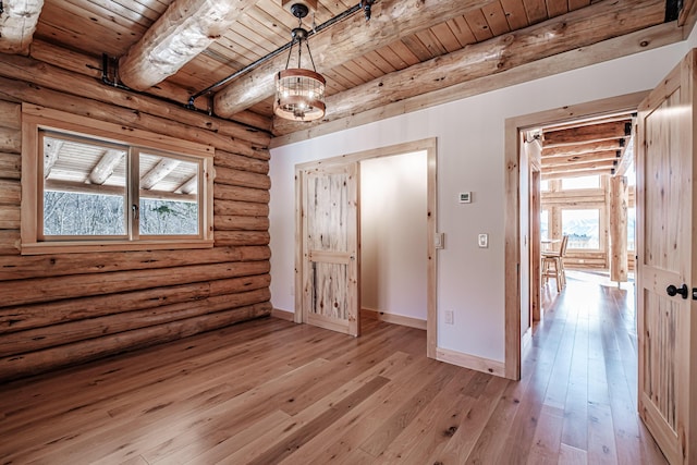 interior space featuring beam ceiling, multiple windows, wood ceiling, and light wood-type flooring