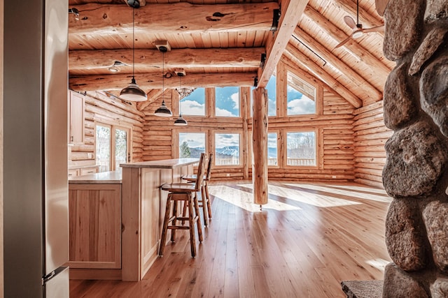 interior space with rustic walls, lofted ceiling with beams, light hardwood / wood-style flooring, wooden ceiling, and bar area