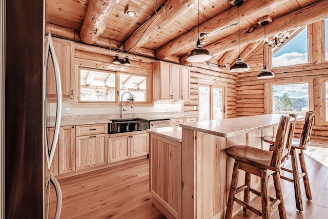 kitchen featuring stainless steel fridge, light hardwood / wood-style flooring, a kitchen island, and wooden ceiling