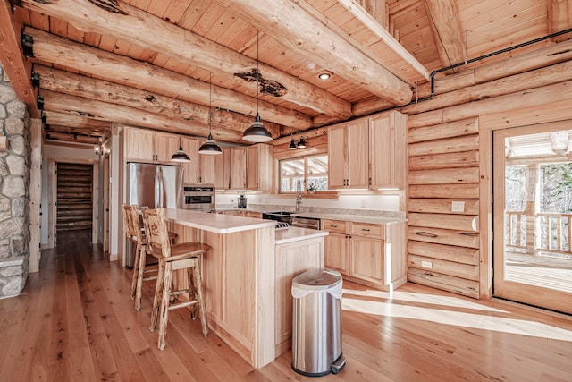 kitchen with a healthy amount of sunlight, a kitchen island, and light hardwood / wood-style floors