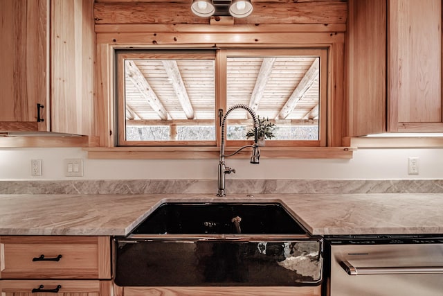 interior details with stainless steel dishwasher, light stone countertops, and sink