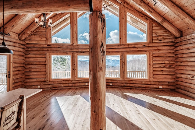 interior space with hardwood / wood-style flooring, a notable chandelier, and wood ceiling