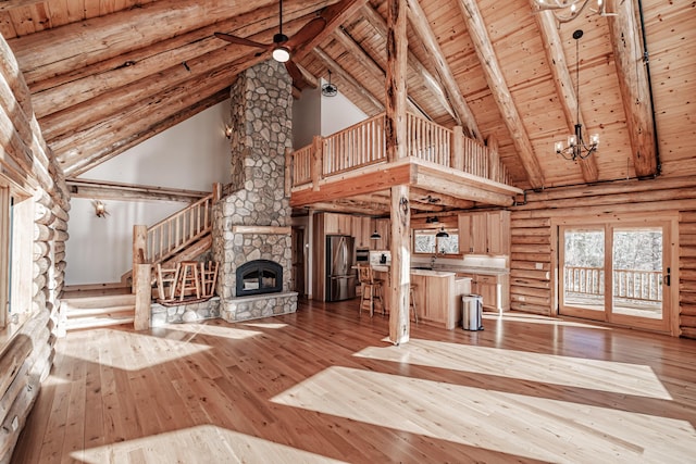 unfurnished living room featuring beam ceiling, a fireplace, high vaulted ceiling, and light hardwood / wood-style flooring