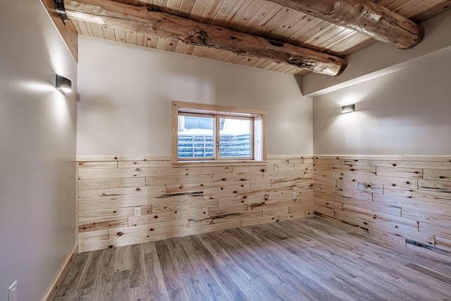 unfurnished room with beam ceiling, wood-type flooring, and wooden ceiling