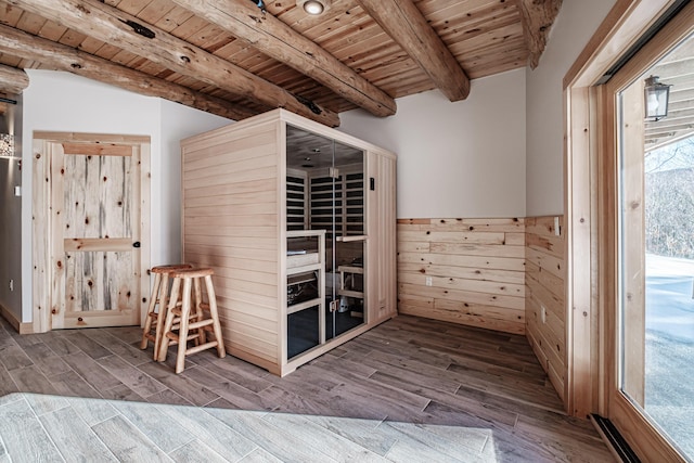 unfurnished bedroom with wood walls, beamed ceiling, wooden ceiling, and hardwood / wood-style flooring