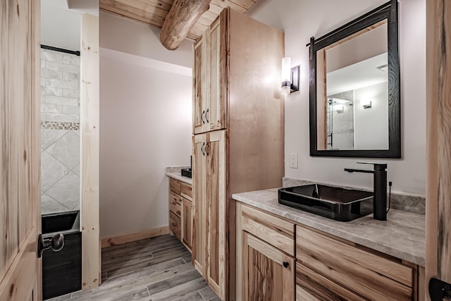 bathroom with beamed ceiling, hardwood / wood-style floors, vanity, and wood ceiling