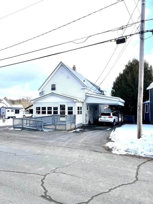 view of front of house with a carport and a wooden deck