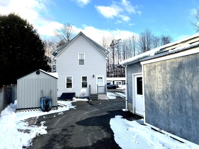 view of snowy exterior with a shed