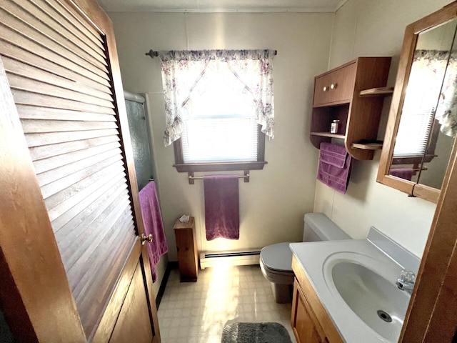 bathroom featuring vanity, toilet, a shower with shower door, and a baseboard heating unit