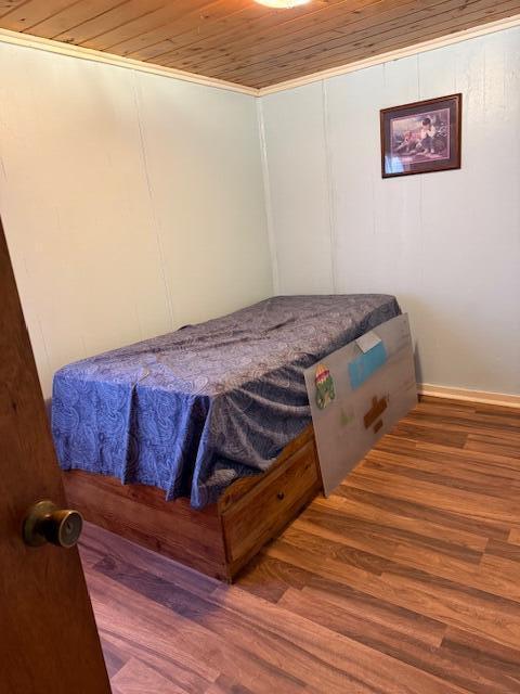 bedroom featuring hardwood / wood-style floors, crown molding, and wood ceiling