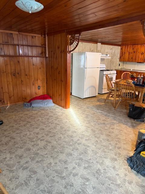 dining area with wood walls and wood ceiling