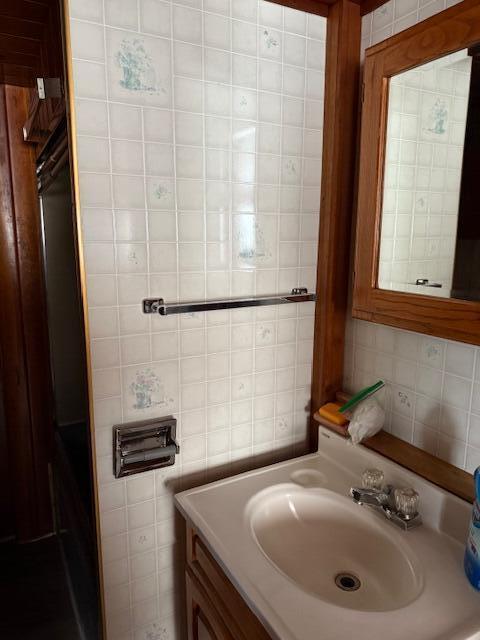 bathroom featuring vanity and tile walls