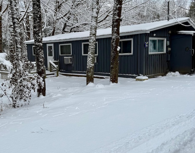 snow covered house featuring cooling unit