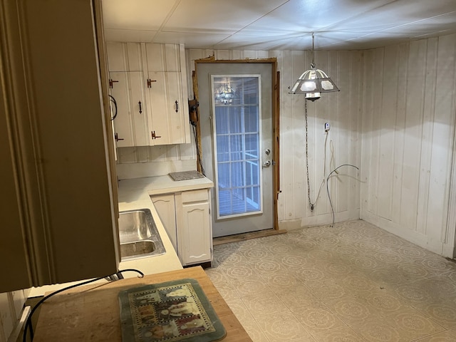 doorway with sink and wooden walls