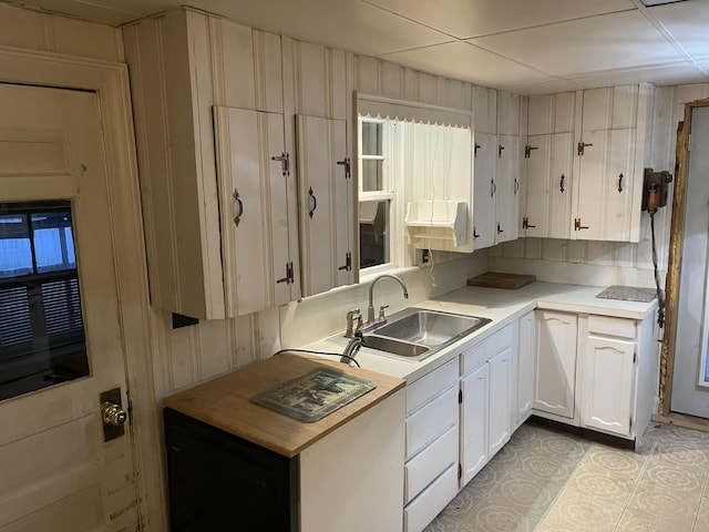 kitchen with white cabinetry, sink, and light tile patterned floors