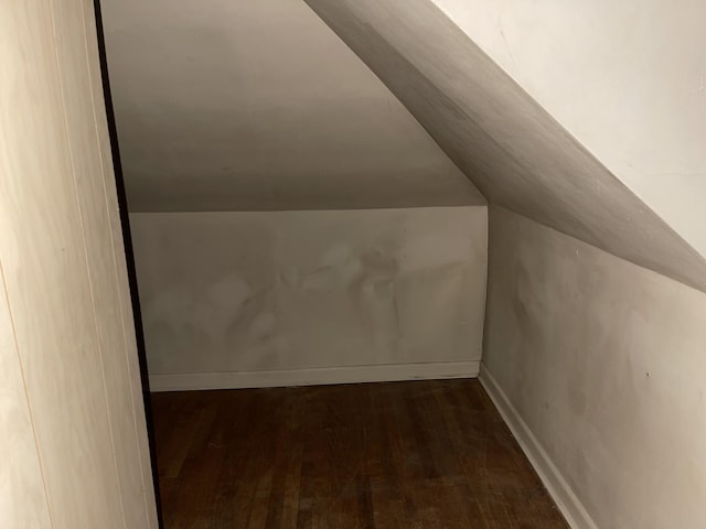 bonus room with dark hardwood / wood-style floors and lofted ceiling