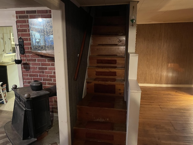 stairway featuring wood-type flooring and wood walls