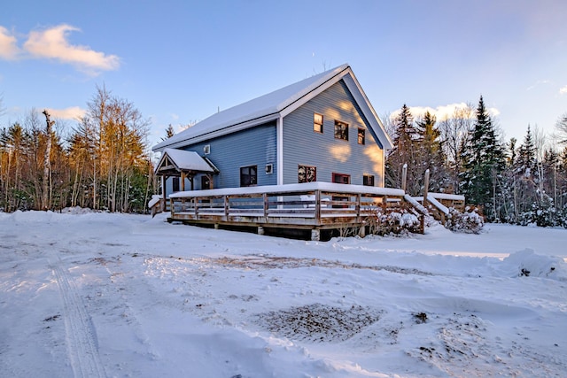 snow covered house with a wooden deck