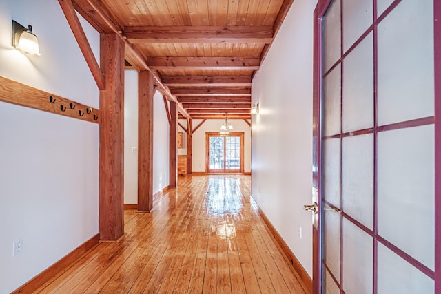 hallway featuring light hardwood / wood-style floors, wood ceiling, beam ceiling, and french doors