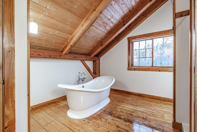 bathroom featuring a bath, hardwood / wood-style floors, vaulted ceiling with beams, and wood ceiling