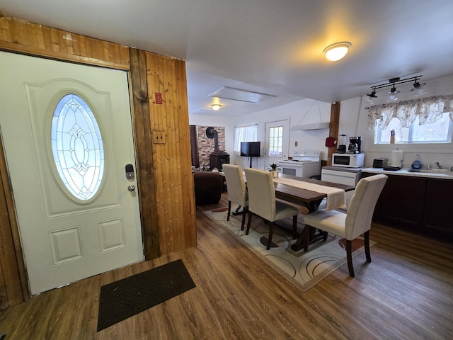 dining space with a wood stove, sink, and hardwood / wood-style flooring