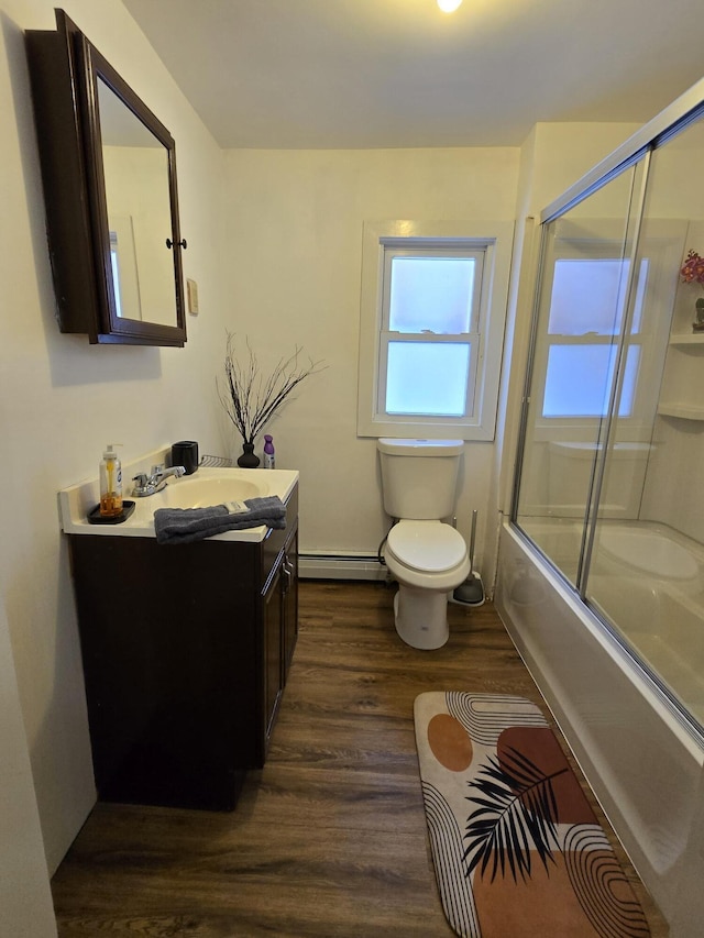 full bathroom featuring vanity, hardwood / wood-style flooring, toilet, enclosed tub / shower combo, and baseboard heating