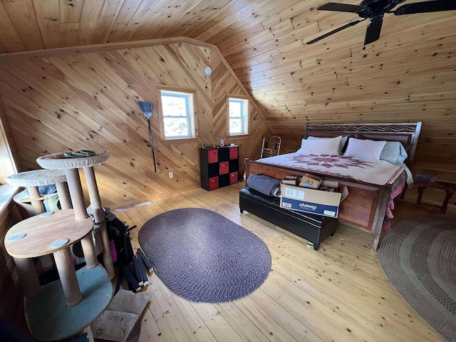 bedroom featuring wood ceiling, vaulted ceiling, ceiling fan, wooden walls, and light hardwood / wood-style floors