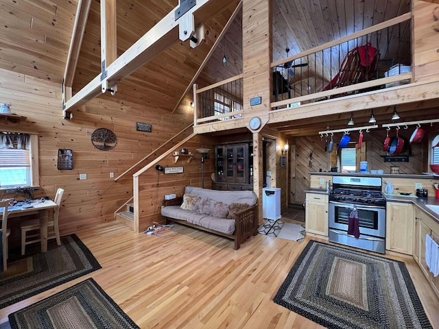 living room with wooden walls, high vaulted ceiling, light hardwood / wood-style floors, and wooden ceiling