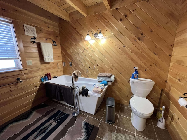 bathroom with tile patterned flooring, a washtub, beam ceiling, and wooden walls