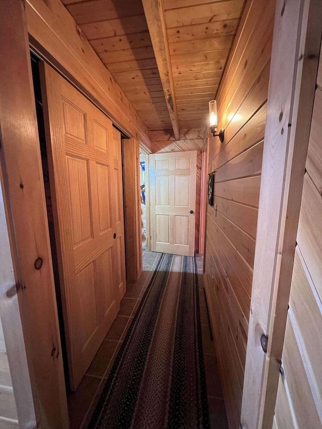 hall with wooden walls, beamed ceiling, and wood ceiling