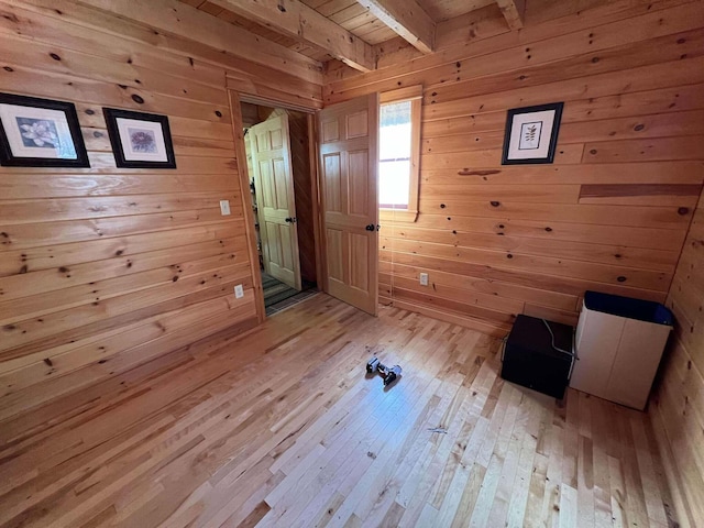 interior space with wood ceiling, beam ceiling, light hardwood / wood-style floors, and wooden walls