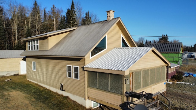 rear view of property featuring a sunroom