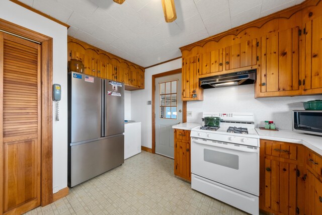 19 Branch Brook Rd, Thomaston, ME 04861 - kitchen with appliances with stainless steel finishes, under cabinet range hood, light countertops, and brown cabinetry