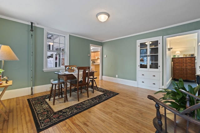 dining space featuring hardwood / wood-style flooring and ornamental molding