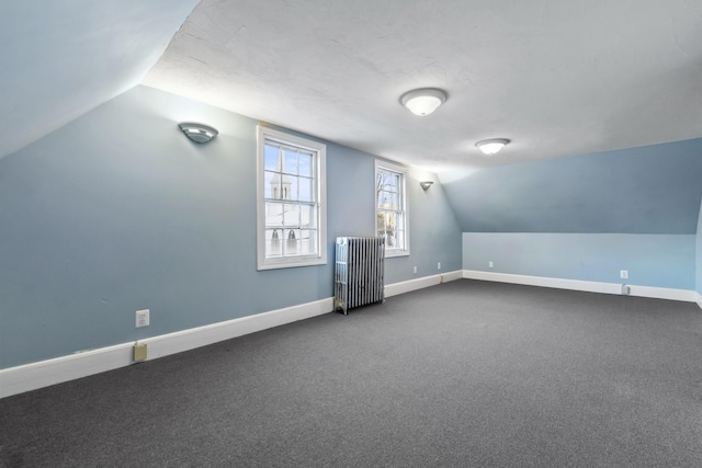 bonus room with radiator, carpet, and vaulted ceiling