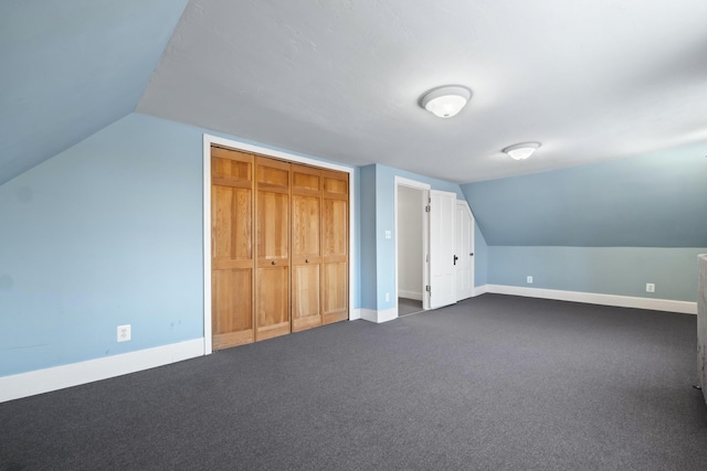 bonus room featuring lofted ceiling and dark colored carpet