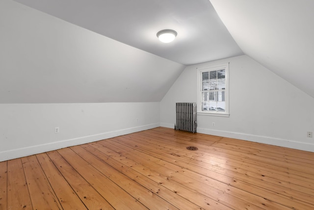 bonus room with light hardwood / wood-style flooring, radiator, and lofted ceiling