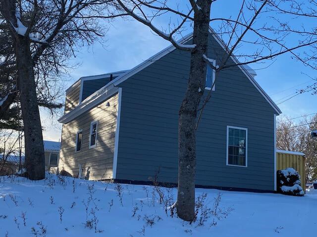 view of snowy exterior featuring a garage