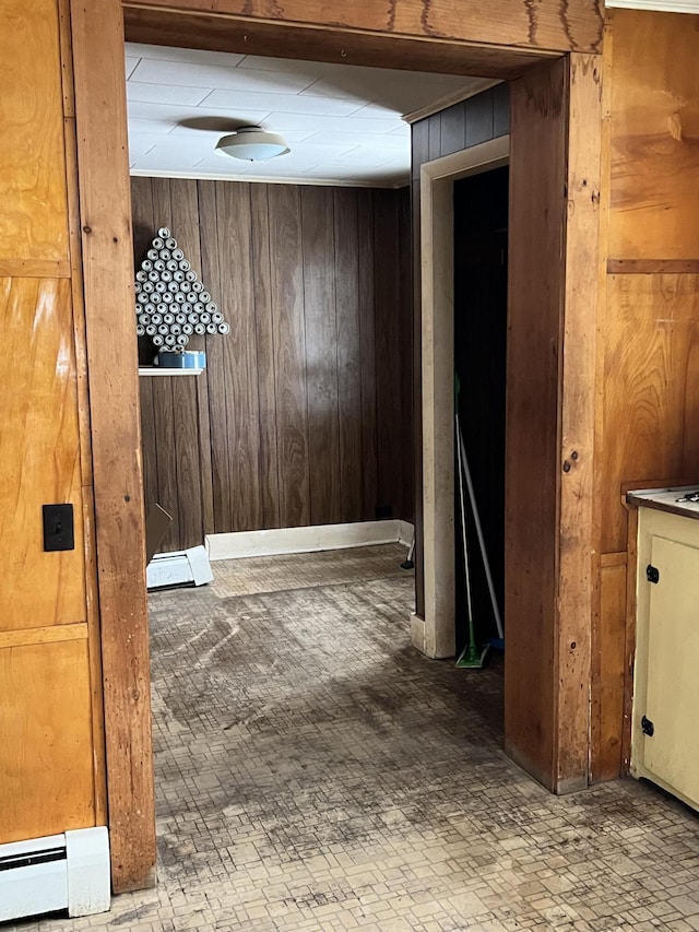 hallway with a baseboard radiator and wood walls