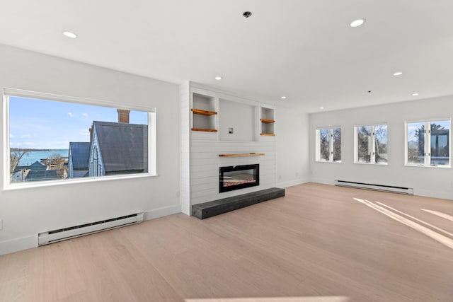 unfurnished living room with light hardwood / wood-style floors and a baseboard radiator