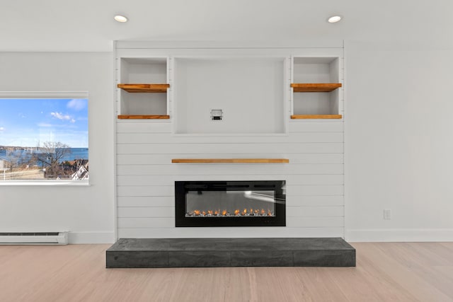 room details with a fireplace, wood-type flooring, and baseboard heating