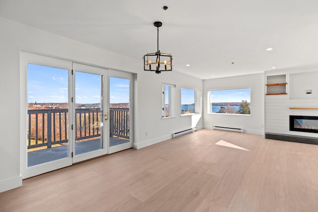 unfurnished living room featuring light hardwood / wood-style floors, baseboard heating, and an inviting chandelier