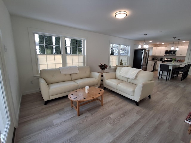 living room featuring light wood-type flooring and an inviting chandelier