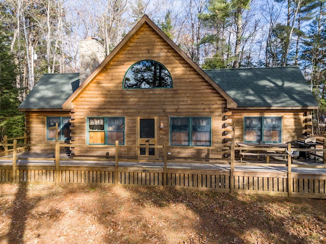 rear view of property featuring a wooden deck