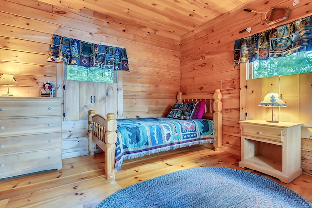 bedroom featuring wood walls, wood ceiling, and hardwood / wood-style flooring